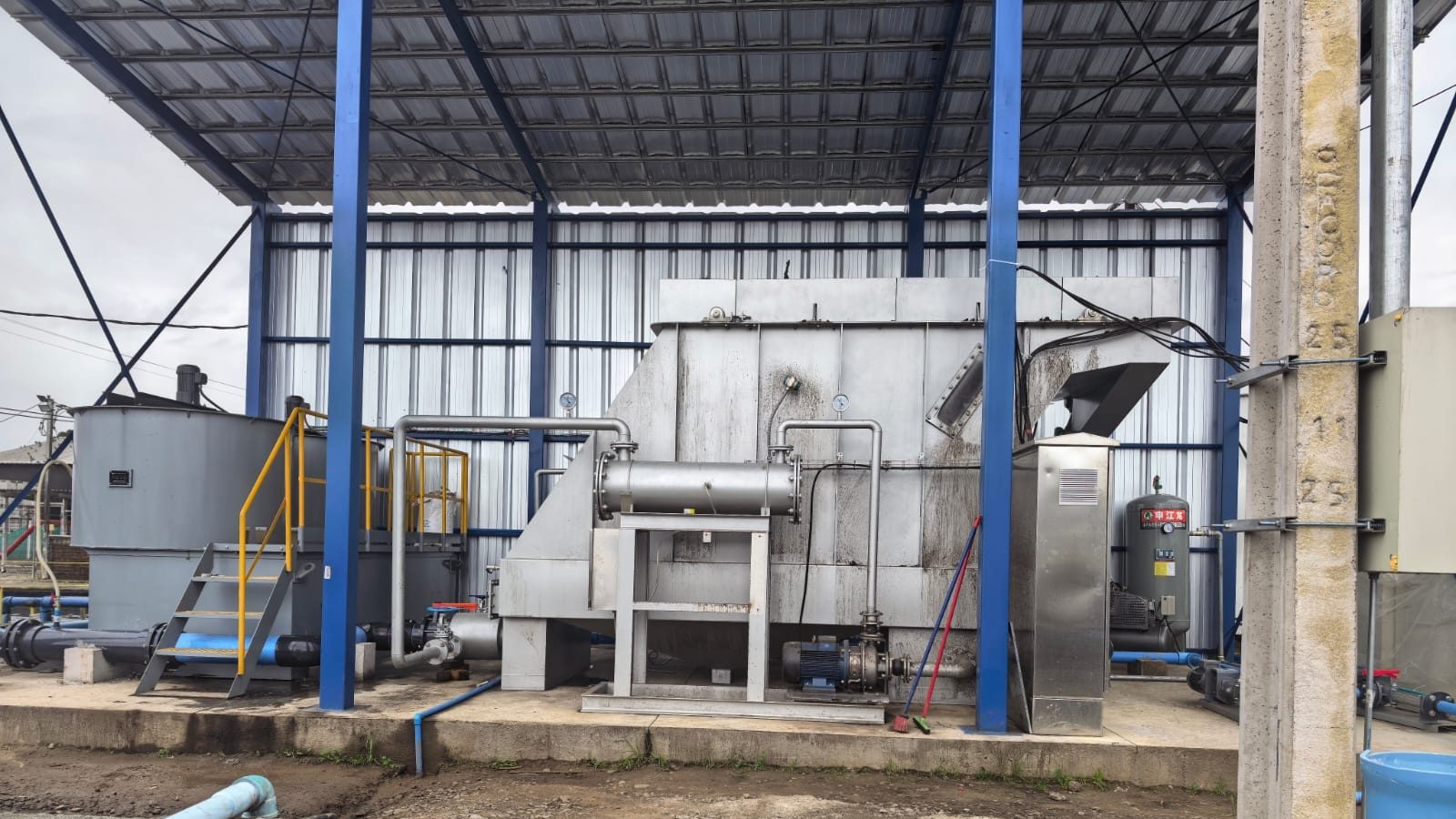 Flotador DAF instalado bajo techo en una planta de tratamiento de riles en Chile, con su tubo de disolución de aire y los estanques de preparación de químicos